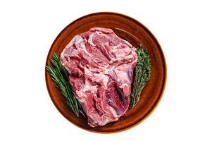 Raw Boneless Lamb leg meat in rustic plate with thyme. Isolated, white background. Top view. photo