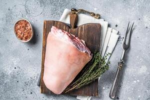 Uncooked Raw pork ham hocks, shanks on a wooden board with spices. Gray background. Top view photo