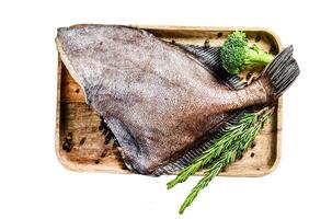 Raw fresh John Dory fish on a wooden tray with rosemary and broccoli. Isolated on white background. Top view. photo