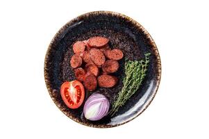 Fried sausage sucuk from beef meat on a plate with herbs. Isolated, white background. Top view. photo