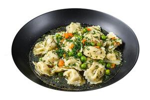 Dumplings Soup with Ravioli pasta in a bowl with greens. Isolated on white background. Top view. photo
