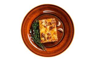 Italian Lasagne with tomato bolognese sauce and mince beef meat on a rustic plate. Isolated on white background. photo