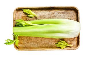 Celery vegetable on wood tray. Isolated on white background. Top view. photo