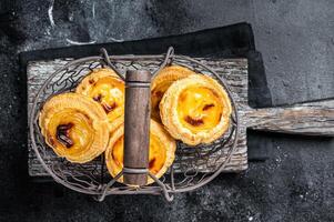 Traditional Lisbon Pasteis de nata in a basket. Black background. Top view photo