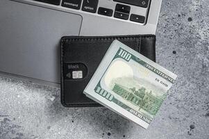 Workplace with stylish leather wallet with money, Laptop. Gray background. Top view. Copy space photo