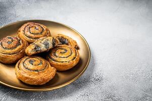 Poppy seed rolls and cardamom buns, Traditional Nordic baked sweet breads on wooden board. White background. Top view. Copy space photo