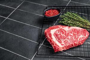 Uncooked wagyu Rib Eye steak, raw beef meat. Black background. Top view. Copy space photo