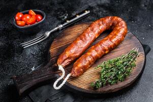 Traditional spanish Chorizo sausage, dry cured pork meat. Black background. Top view photo