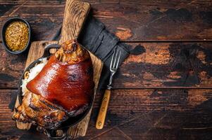 Bavarian Schweinshaxe Roast pork Hock Ham, knuckle with Sauerkraut. Wooden background. Top view. Copy space photo