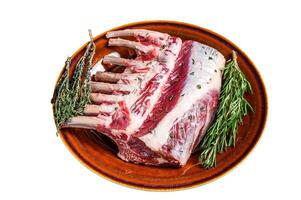 Raw fresh rack of lamb with green herbs. Isolated on white background. photo