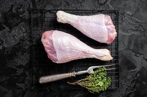 Raw turkey legs on a butcher table. Black background. Top view photo