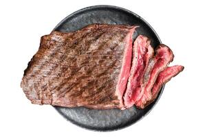 Grilled Flap or Flank Steak, sliced on a plate. Isolated on white background. photo