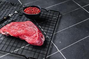 Raw beef meat piece for grilling with spices. Black background. Top view. Copy space photo