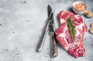 Raw Pork steaks, fresh meat on butcher table. Gray background. Top view. Copy space photo