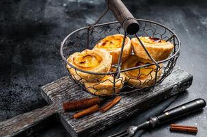 Traditional Lisbon Pasteis de nata in a basket. Black background. Top view photo