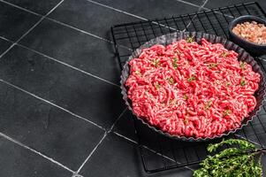 Raw Minced beef and pork meat for a burger patty or meatballs. Black background. Top view. Copy space photo