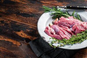 Pieces of raw turkey thigh, Poultry fresh meat. Wooden background. Top view. Space for text photo
