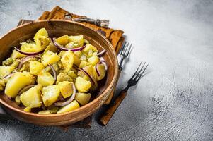 Bowl of warm potato salad with bacon, German Kartoffelsalat. White background. Top view. Copy space photo