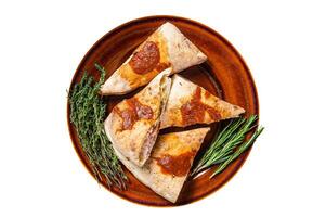 Calzone pizza pieces on rustic plate with tomato sauce and herbs. Isolated, white background. Top view. photo