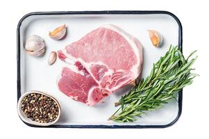 Ready for cooking Raw pork t-bone chop meat steak with herbs and spices. Isolated, white background. photo