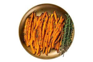 Baked sweet potato fries on a plate with herbs. Isolated on white background. photo