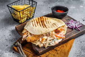 Doner kebab, Shawarma in grilled pita bread with vegetables and meat. Gray background. Top view photo