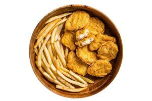 Crispy fried Chicken nuggets with French fries in wooden plate. Isolated, white background. Top view. photo
