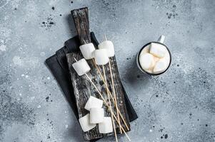 Marshmallow on the stick ready for BBQ. Gray background. Top view photo