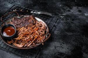 Slow Cooked Pulled Beef, Traditional meat rubbed with spices and smoked in a Texas smoker. Black background. Top view. Copy space photo