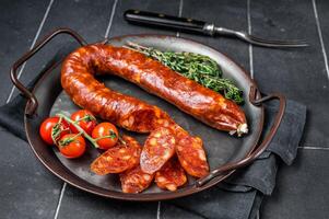 Sliced Chorizo sausage, slices of dry cured pork with herbs and spices. Black background. Top view photo