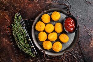 Potato croquettes, mashed potatoes balls breaded and deep fried. Dark background. Top view photo