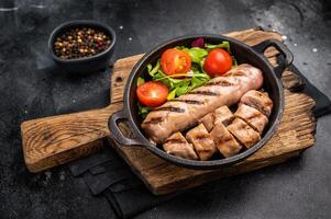 cena con ensalada y A la parrilla Cerdo salchichas en un sartén. negro antecedentes. parte superior ver foto