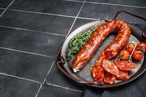 Sliced Chorizo sausage, slices of dry cured pork with herbs and spices. Black background. Top view. Copy space photo