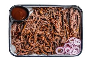 Pulled beef meat with hot chili sauce in baking dish. Isolated on white background. photo