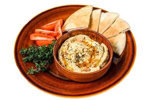 Fresh Hummus with pita bread, tomato and parsley on a rustic plate. Isolated on white background. photo