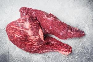 Raw tri tip beef steak on kitchen table. White background. Top view photo