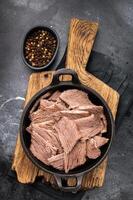 Cooked Boiled lamb meat in a skillet. black background. top view photo