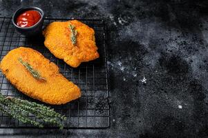 Fried Breaded weiner schnitzel, cooked meat steak. Black background. Top view. Copy space photo