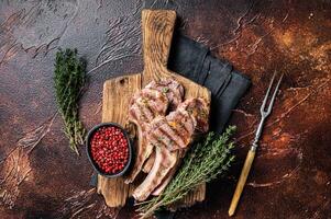 Grilled New Zealand Lamb Chops, mutton cutlets on wooden board. Dark background. Top view photo