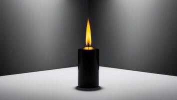 A black candle with a yellow flame on a dark background reflects the candle's image perfectly in the middle of the frame. photo