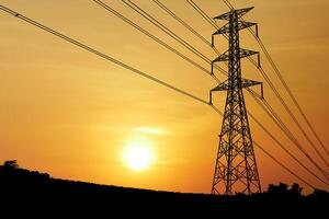 Stunning Sunset Behind Power Lines Silhouetted Against a Vibrant Orange Sky in a Serene Landscape photo