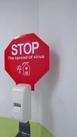 Disinfectant with stop sign in clinic. Woman with a child comes to the elevator near the caution sign the spread of virus in hospital. Virus outbreak. Vertical video