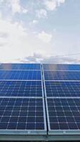 azul solar painel debaixo a luz solar. fotovoltaico bateria debaixo a céu. renovável verde alternativo energia. fechar-se. vertical video