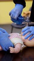 Students practice cpr on a doll. Instructor teaching the proper medical procedure for saving people's life on a dummy. Vertical video