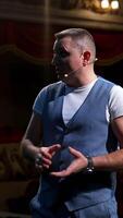 Portrait of a male actor. Middle-aged man speaking during the rehearsal while standing on stage. Comedian in the theater. Vertical video