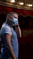 Actor in medical mask on theatre scene. Man rehearsing on stage and taking off protective mask while leading monologue. Pandemic in the world. Vertical video