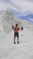 Man with weight training on nature. Handsome man doing biceps lifting on nature. Vertical video
