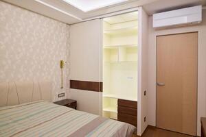 Stylishly Modern Bedroom Design Featuring Builtin Wardrobe and Efficient Air Conditioning photo