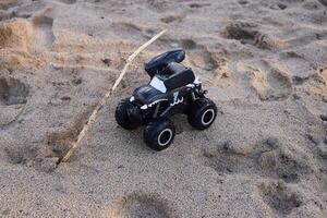 Experience the thrill of a RemoteControlled Monster Truck driving across a sandy beach photo