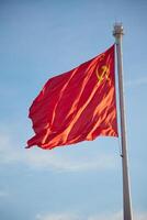 The Flag of the Soviet Union is proudly waving against the vast and beautiful sky above photo